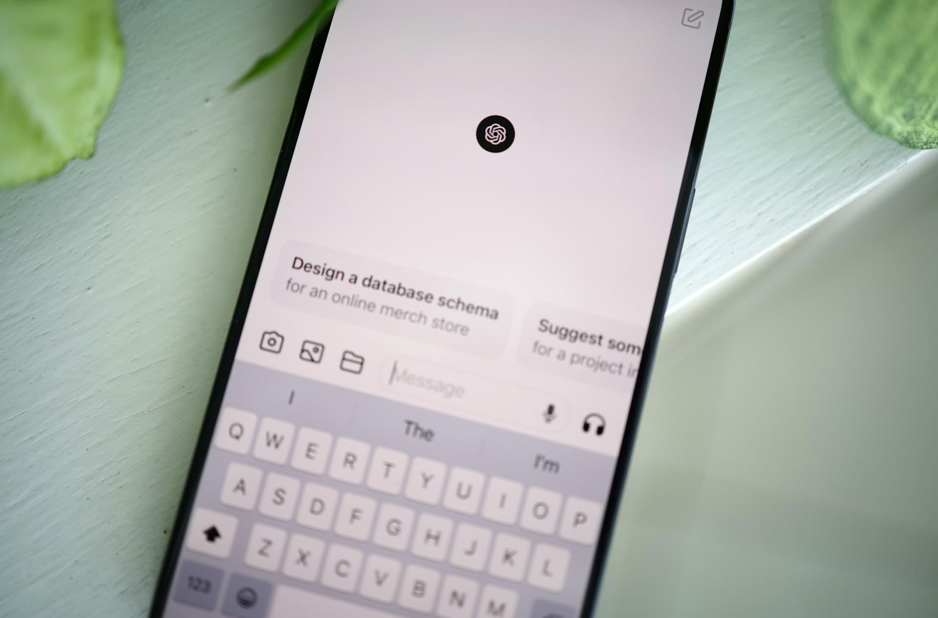 ChatGPTのアプリが表示されたスマートフォンが机の上に置かれている写真